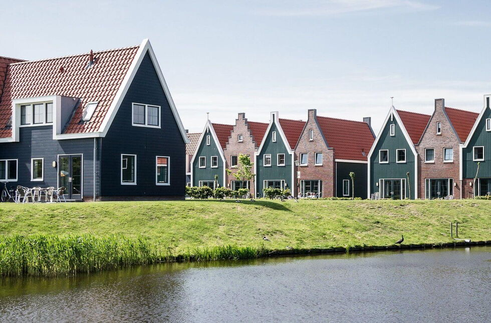 Huis met NL blokprofiel kozijnen met wit frame en groene vleugel