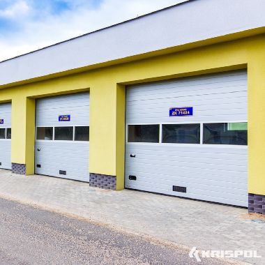 Industrie-Sektionaltor von Krispol mit Lichtband und gelber Fassade