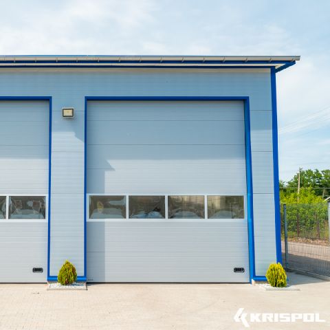 Industrie-Sektionaltor vom Hersteller Krispol mit Lichtband und schmalen Sicken in Hellgrau