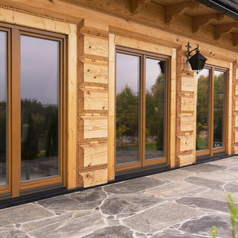 Houten raam tot op de vloer bij een houten tuinhuis