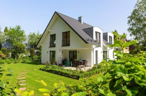 Haus mit bodentiefen Fenstern und Geländer